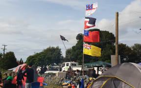 There are a range of flags on show, including (from top to bottom) the United Tribes of New Zealand flag, the tino rangatiratanga flag, the Samoan flag and the Nuienan flag, to represent the unity of all nations.