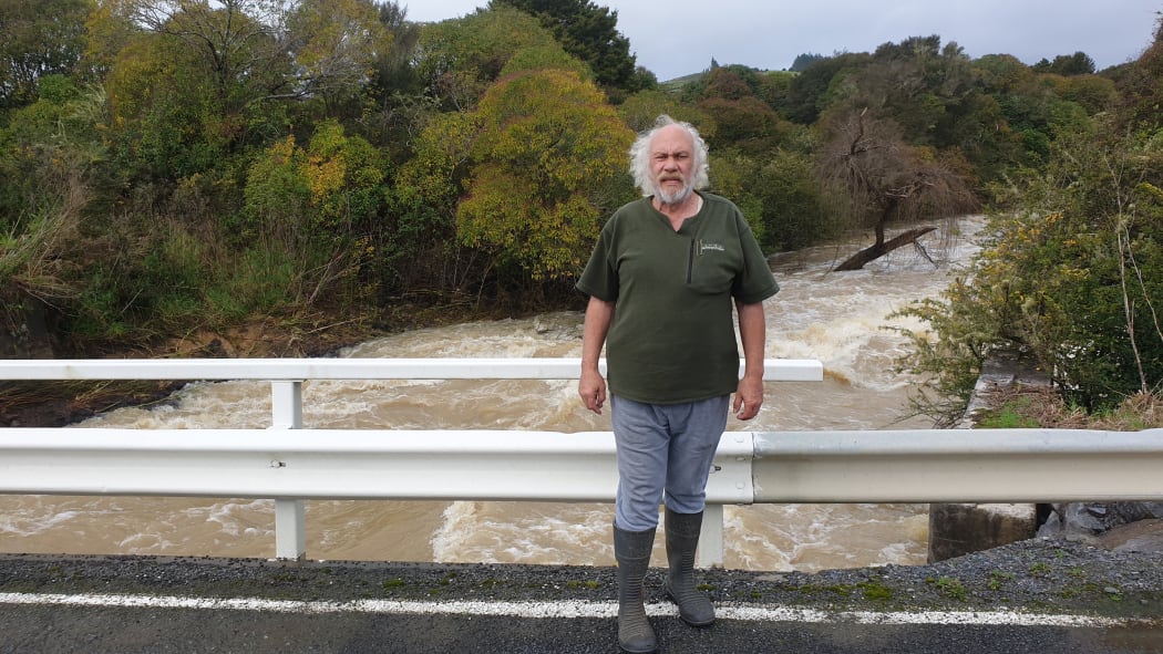 Mike Butler on a bridge above the raging Waiharakeke Stream