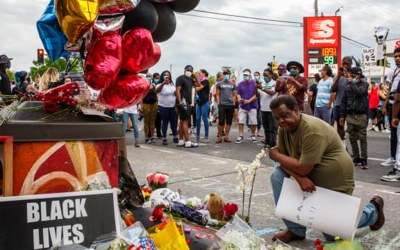A man prays in front of a makeshift memorial in honor of George Floyd who died in custody on May 26, 2020 in Minneapolis, Minnesota.