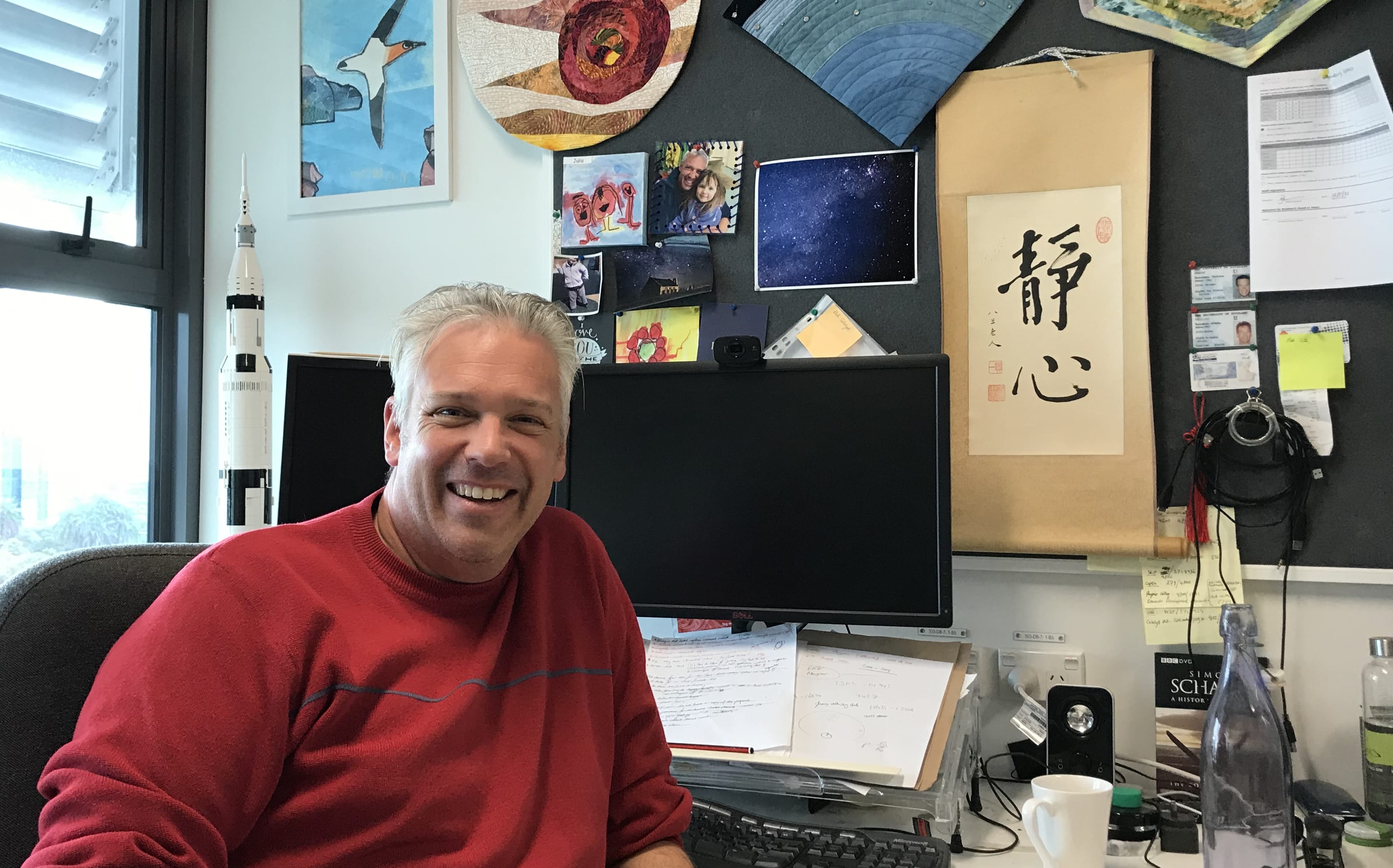 Dr. Nicholas Rattenbury in his office, with a rocket model behind him.
