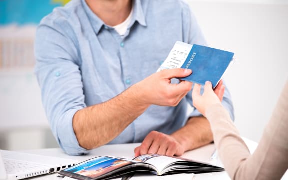 Close up photo of male travel agent and young woman. Young man giving tickets and passport with visa to female tourist