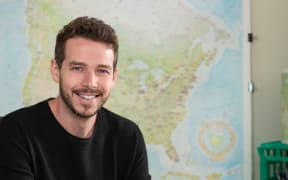 Anton Thomas in front of a map