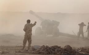 Iraqi Shiite fighters from a Popular Mobilisation unit use mobile artillery near the city of Fallujah.