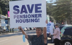 Napier council flat resident Colleen Fryer protesting outside a council meeting on 18 May 2022.