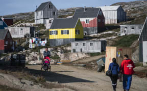 People walking in Kulusuk, Greenland.