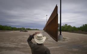 In this file photo taken on March 28, 2021, ranch owner Tony Sandoval (67) stands before a portion of the unfinished border wall that former US president Donald Trump tried to build, near the southern Texas border city of Roma.