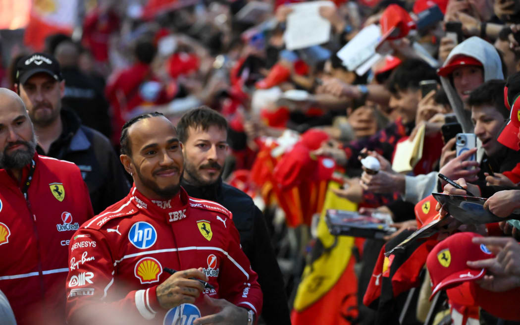 British F1 driver Lewis Hamilton signs autographs during the Scuderia Ferrari event in Milan, 2025.