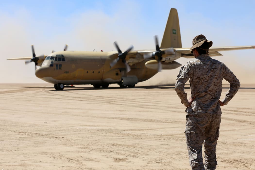 Saudi soldiers stand guard as a Saudi air force cargo plane, carrying aid, lands at an airfield in Yemen's Marib, on 8 February, 2018.