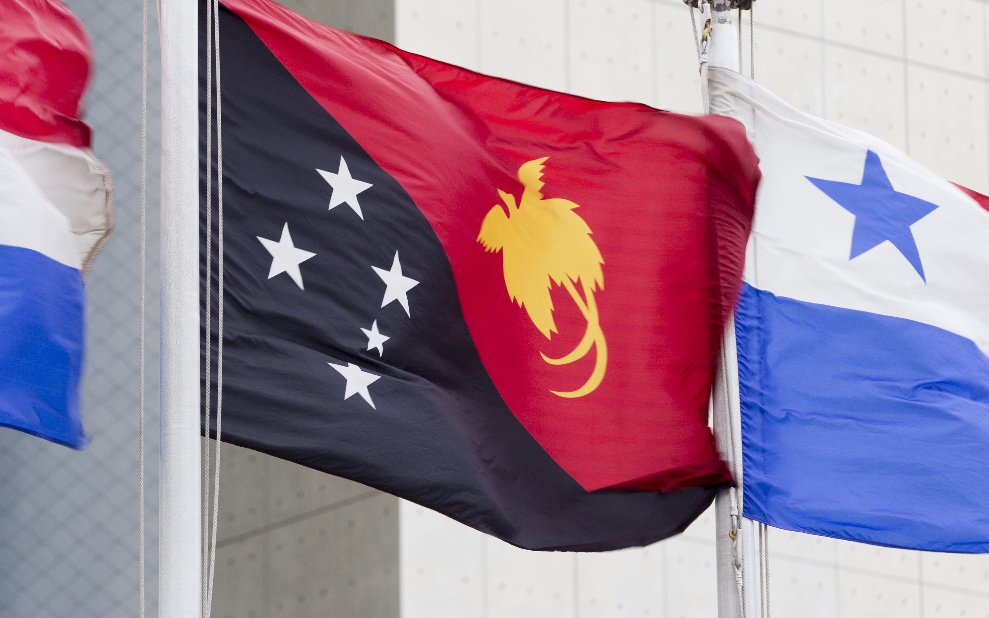 The flag of the Independent State of Papua New Guinea (centre) flying at United Nations headquarters in New York.14 July 2016 United Nations, New York