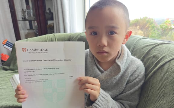 Raymond Hsu holding up his certificate - the first Cambridge grade he received for the International Mathematics exam in June last year.