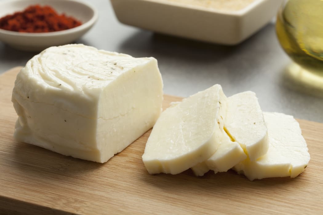 Piece of fresh sliced halloumi on a cutting board