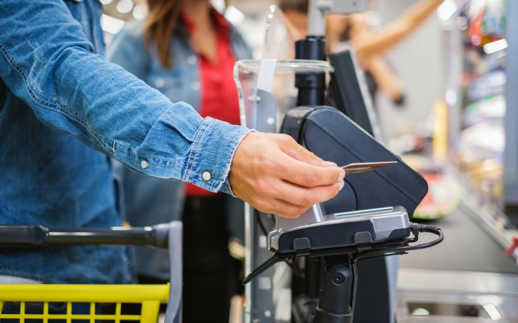 Man paying with NFC in a grocery store.