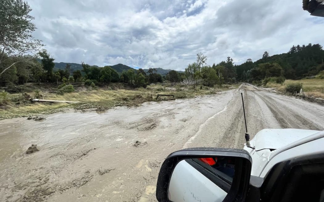 Crews worked to restore a cable which was torn from a bridge near Tologa Bay by the swollen Hikuwai River after Cyclone Hale.