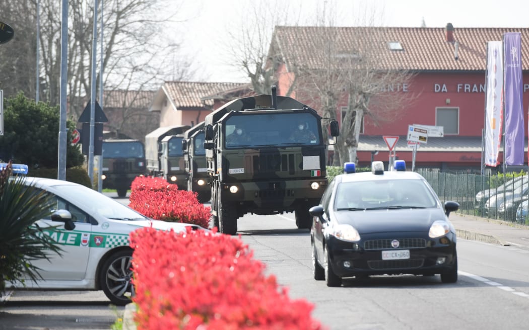 This picture shows a military convoy outside the church of San Giuseppe in Seriate, Italy on March 28, 2020, as coffins of people deceased from the COVID-19 novel coronavirus are carried to be blessed inside the church.