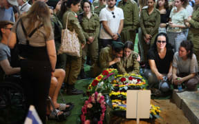 Relatives and friends mourn by the grave of Israeli soldier Eitan Itzhak Oster killed in fighting in the northern border area with Lebanon, during his funeral  at the Mount Herzl Military Cemetery in Jerusalem on October 2, 2024. Confirmation of the fighting in two areas of the border came hours after Iran launched its second-ever direct attack on Israel, with the Israeli army announcing that eight soldiers have been killed so far in combat in southern Lebanon. (Photo by Ahmad GHARABLI / AFP)