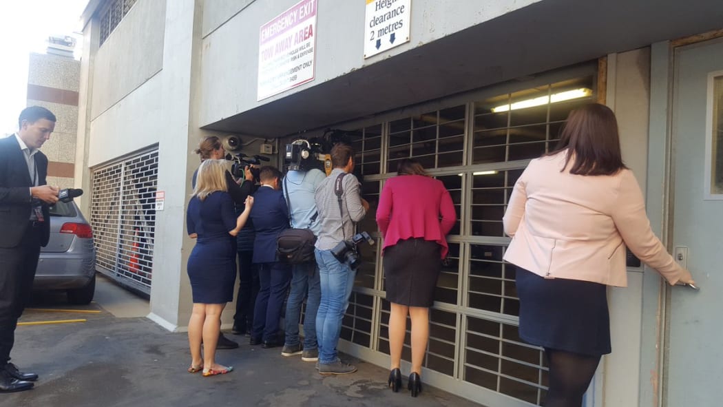 Political reporters peeking for clues through a garage door in the Beehive.