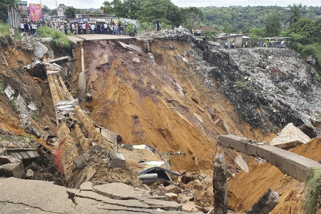 A road surface swept away by a landslide caused by torrential overnight rains is photographed in the Lemba district of Kinshasa, on November 26, 2019.