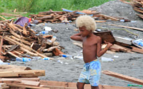 A boy among the rubble left by flooding in the Solomon Islands.