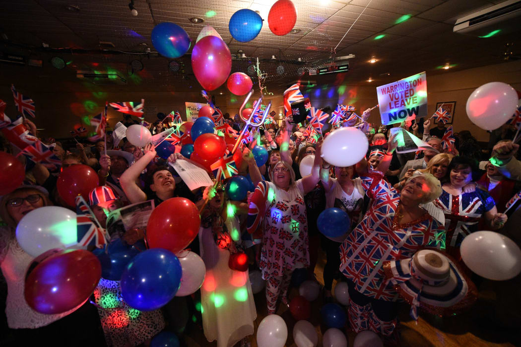 Brexit supporters wave Union flags as the time passes 11 O'Clock at a Brexit Celebration party at Woolston Social Club in Warrington.