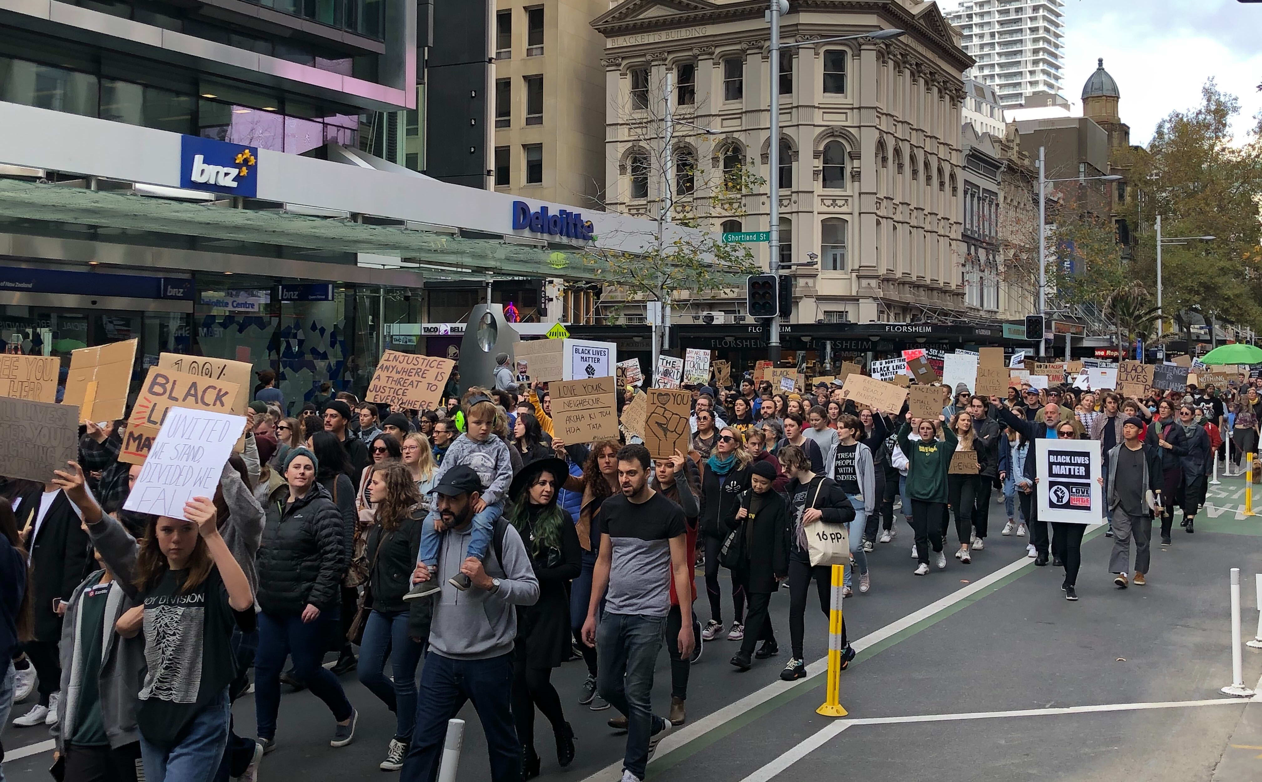 The Black Lives Matter protesters make their way down Queen Street in Auckland.