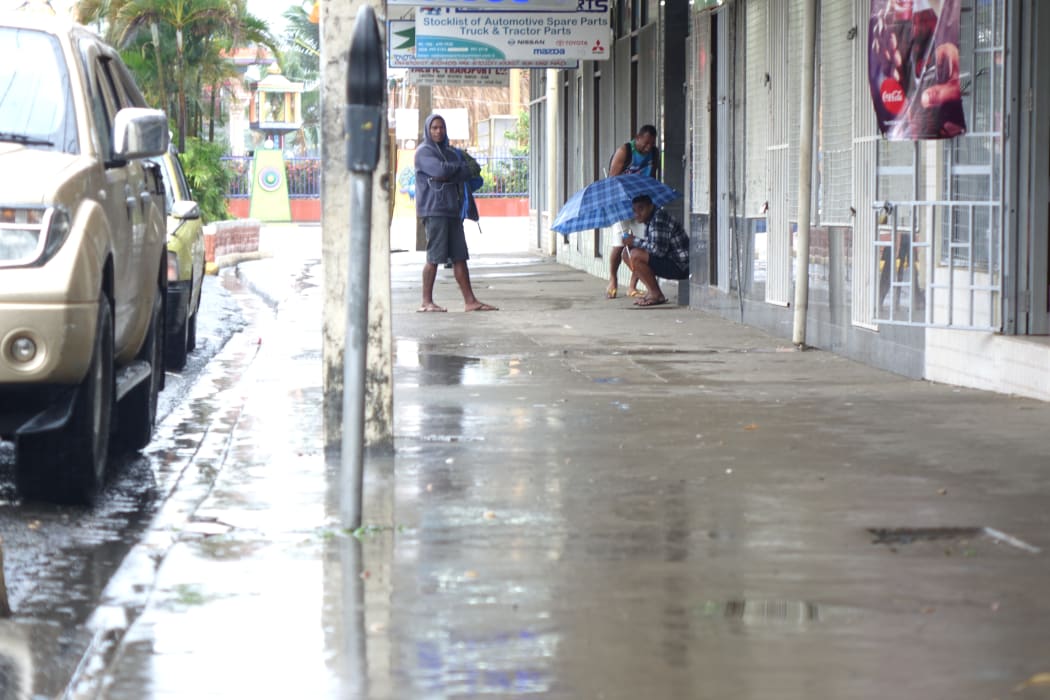 Fijians shelter from heavy rain in Nadi.