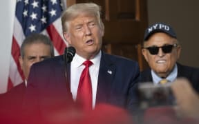 President Donald Trump's personal lawyer Rudy Giuliani listens as US President Donald Trump delivers remarks to the City of New York Police Benevolent Association at the Trump National Golf Club in Bedminster, NJ, on August 14, 2020.