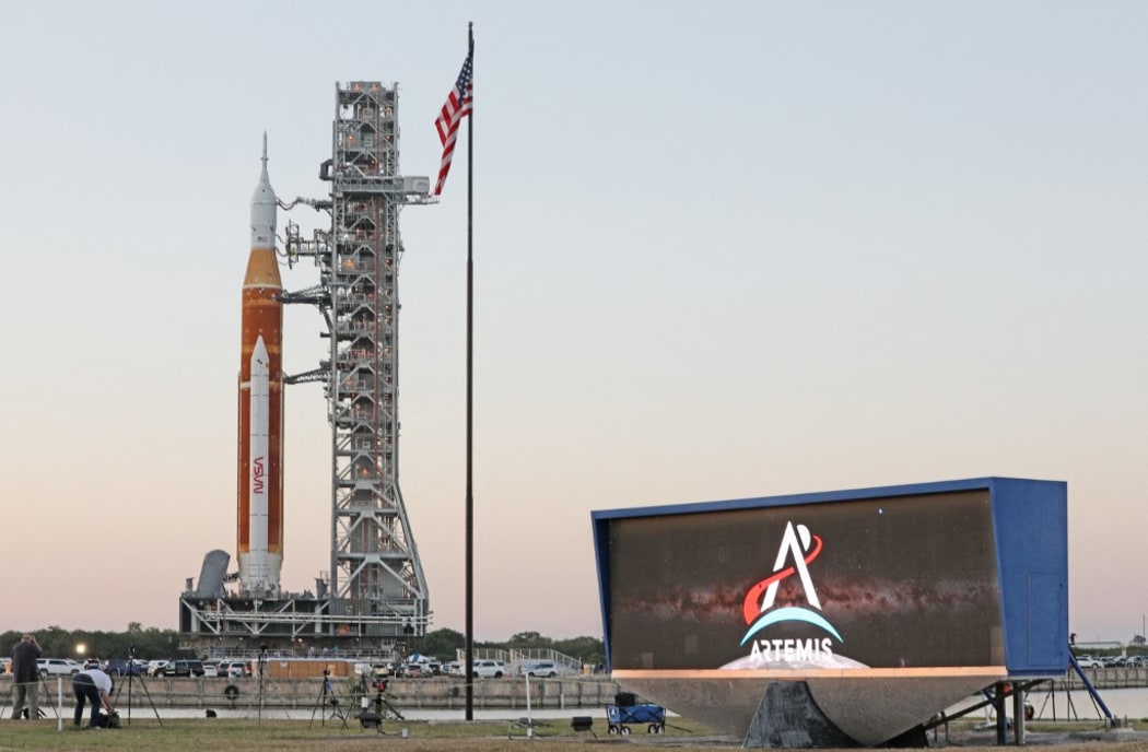 The massive Artemis I rocket rolls past the countdown clock atop a mobile launch platform en route to Launch Pad 39B from the Vehicle Assembly Building at the Kennedy Space Center in Florida March 17, 2022.