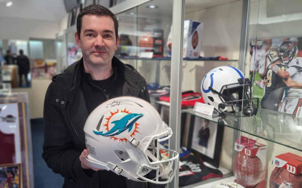 Daniel Wells with a replica of Miami Dolphins quarterback Tua Tagovailoa which was on sale at Card Crazy.
