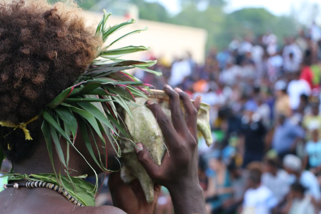 A Solomon Islands' cultural performer blows a conch shell to announce the arrival of Pacific leaders for the RAMSI farewell events. June 2017