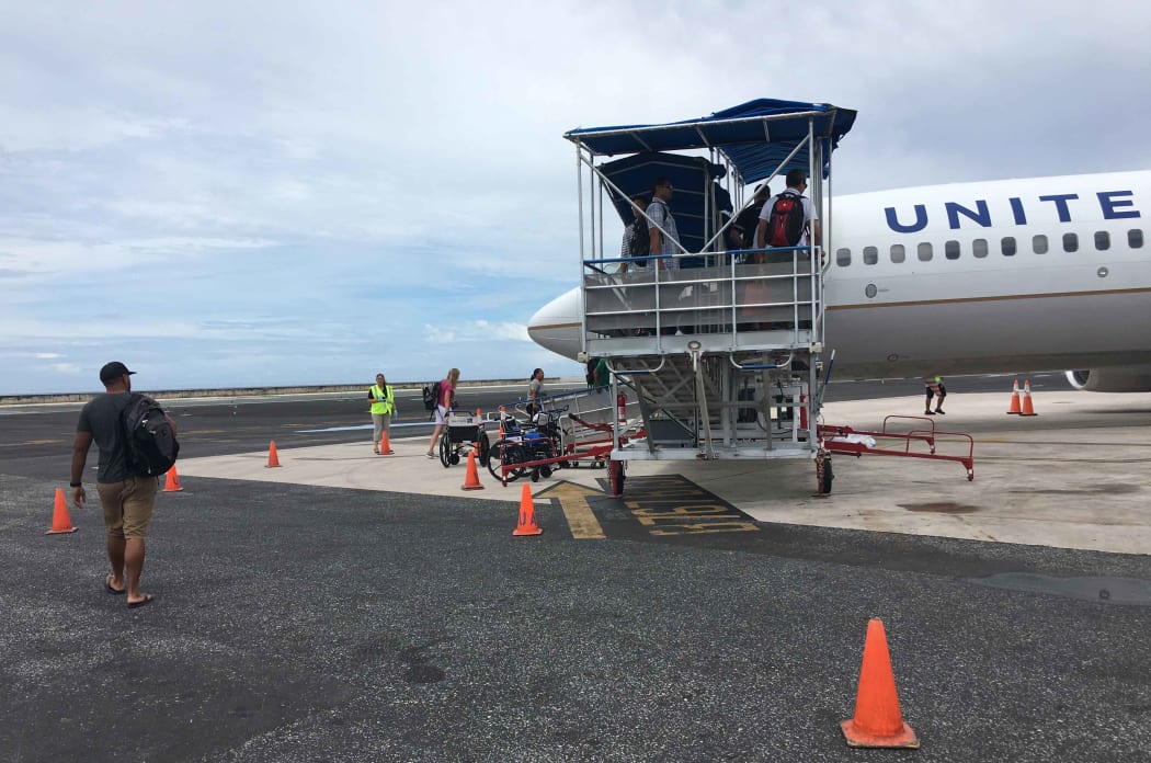 Passengers board a United Airlines flight in Majuro. For the first time in late January, Marshall Islands Immigration officials detained several passengers at Majuro's international airport for questioning in relation to participation in illegal adoptions in the United States.
