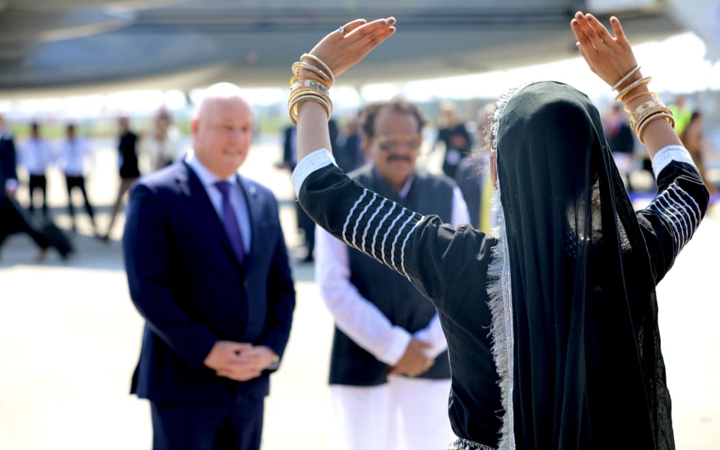 Christopher Luxon views a dance performance with Indian government minister Prof. S.P Singh Baghel after landing at Palam Air Force Station in New Delhi