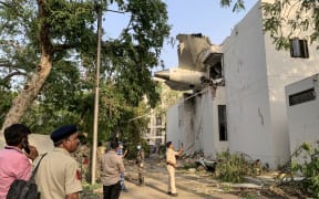 The back of Air India flight 171 is pictured at the site after it crashed in a residential area near the airport in Ahmedabad on June 12, 2025. A London-bound passenger plane crashed in the Indian city of Ahmedabad on June 12 and all 242 people on board were believed killed, with the jet smashing into buildings housing doctors and their families. (Photo by Sam PANTHAKY / AFP)