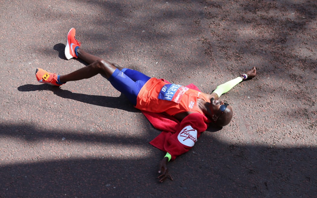 Mo Farah of Great Britain on the ground after crossing the finishing line in 3rd place in 2018 London Marathon.