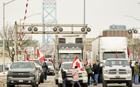 Supporters of the truckers convoy against the Covid-19 vaccine mandate block traffic in the Canada bound lanes of the Ambassador Bridge border crossing, in Windsor, Ontario. 8 February 2022.