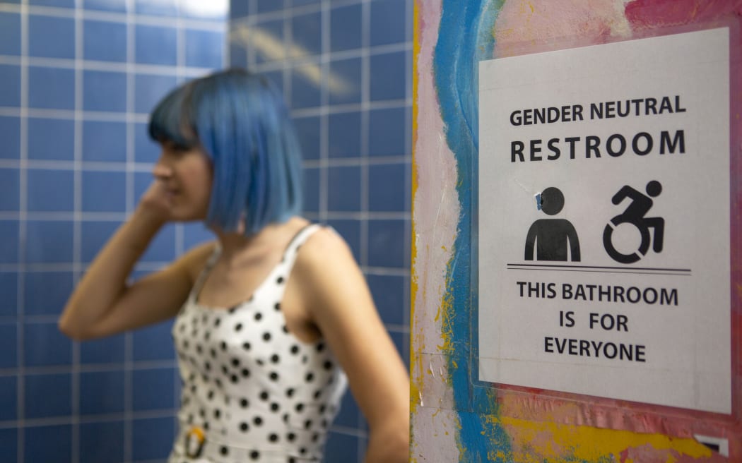 A non-binary femme in a gender neutral bathroom.
