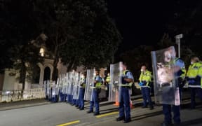 Police hold riot shields after a stand-off with protesters on Hill Street, near Parliament, on 23 February, 2022.