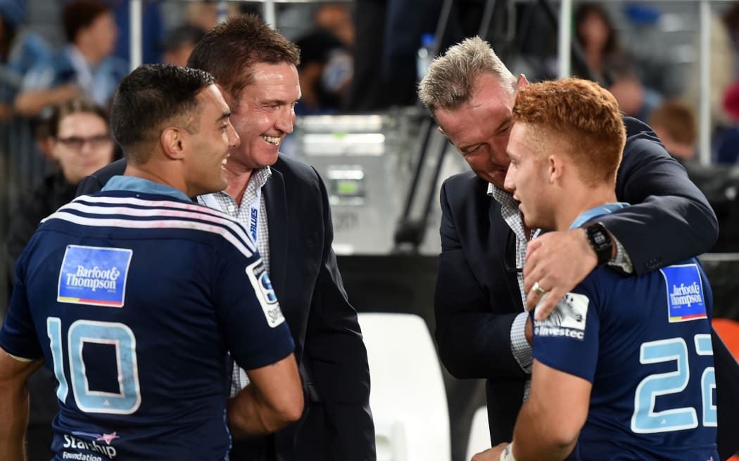 Glenn Moore (2nd from L) and Daniel Bowden look on as then-Blues coach Sir John Kirwan embraces Ihaia West after West's winning penalty in the Super Rugby match against the ACT Brumbies at Eden Park Friday 10 April 2015. Copyright Photo: Andrew Cornaga / www.Photosport.co.nz