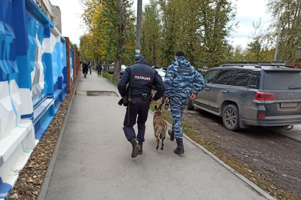 Police officers walk near Perm State University, in Perm, Russia after a shooting from some non-lethal weapons at the state university in Perm.