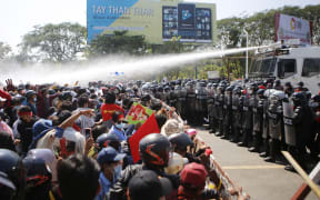 Police fire water cannon at protesters as they demonstrate against the 1 February   military coup in the capital Naypyidaw, 9 February, 2021.