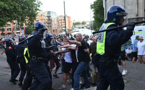 Police officers face off with protesters during the 'Enough is Enough' demonstration called by far-right activists in Bristol on 3 August, 2024. Far-right protesters clashed with British police during tense rallies as unrest linked to disinformation about a mass stabbing that killed three young girls spread across the UK.