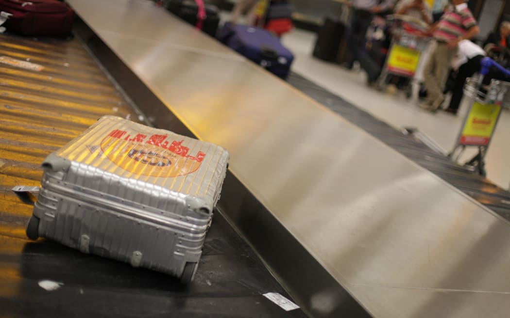 A lone bag sitting on a luggage carousel in an airport.