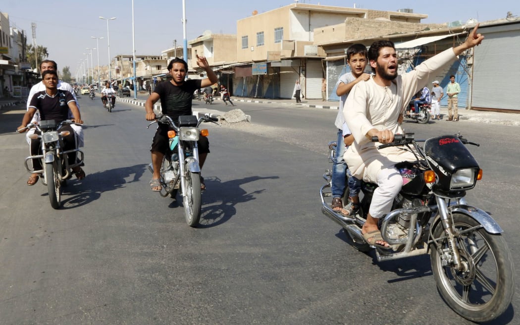 Residents of Tabqa city and Islamic State militants tour the streets in celebration after Islamic State militants took over Tabqa air base.