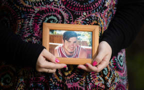 Natasha Toms holds a picture of her brother Jerrim Toms