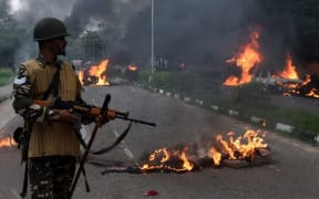 Burning vehicles set alight by rioting followers of a popular religious leader in north India.