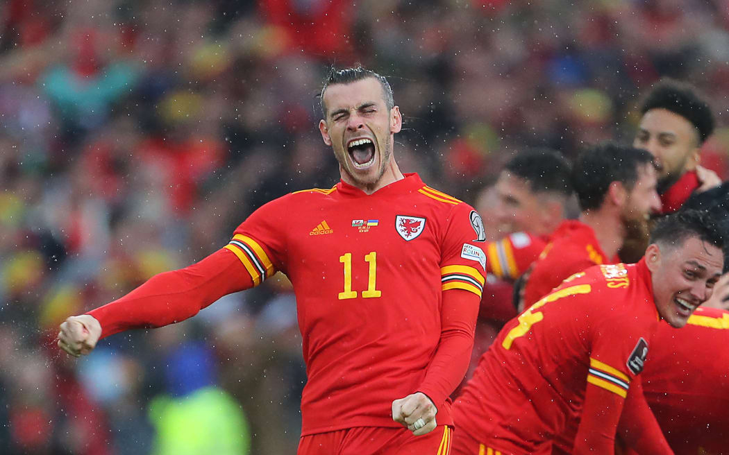 Wales' striker Gareth Bale (L) celebrates with teammates after winning the FIFA World Cup 2022 play-off final qualifier football match between Wales and Ukraine at the Cardiff City Stadium in Cardiff, south Wales, on June 5, 2022. (Photo by Geoff Caddick / AFP)