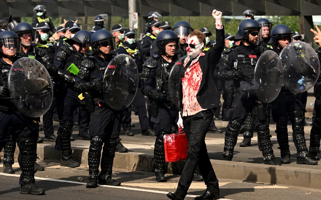 A protester confronts police outside the Land Forces 2024 arms fair in Melbourne on September 11, 2024. (Photo by William WEST / AFP)