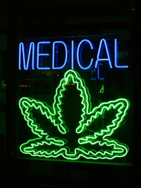 A lit-up sign depicting a marijuana leaf below the word 'medical'