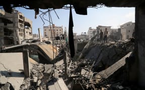 Palestinians inspect the site of an Israeli strike that damaged and destroyed residential buildings, at Shati refugee camp, in Gaza City, 4 July.