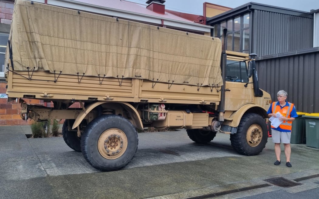 Sue Robertson from Rodney Neighbourhood Support stands beside a Defence Force Unimog at Warkworth Town Hall. She is coordinating activity at the Emergency Centre located at the town hall.