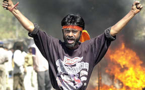 This file photograph taken in 2002 shows an Indian Bajranj Dal activist armed with a iron stick shouting slogans against Muslims.